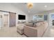 Bright living room features vaulted ceiling, large sectional sofa, a barn door, and access to the outdoor area at 1087 Piedmont Rd, Venice, FL 34293