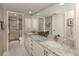 Bathroom vanity featuring double sinks, granite countertops and a shower with glass doors in neutral tones at 1100 Capri Isles Blvd # 423, Venice, FL 34292