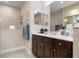 Contemporary bathroom featuring a dual-sink vanity and a glass-enclosed shower at 11172 Mc Dermott Ct, Englewood, FL 34223