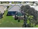 Backyard view of a home with screened-in pool and patio, overlooking a beautiful landscaped backyard at 1125 Deardon Dr, Venice, FL 34292