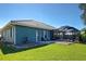 The backyard features a screened lanai, green lawn, and beautiful waterfront views for relaxation at 1125 Deardon Dr, Venice, FL 34292