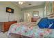 Comfortable bedroom featuring a large bed, mounted TV, and an ensuite bathroom with a view at 1125 Deardon Dr, Venice, FL 34292