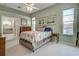 Bright bedroom with floral bedding, ensuite bathroom, and ample natural light from the large window at 1125 Deardon Dr, Venice, FL 34292