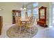 Dining room with decorative rug, neutral walls, chandelier, and multiple windows at 1125 Deardon Dr, Venice, FL 34292
