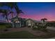Beautifully landscaped home with palm trees against a picturesque twilight sky at 1125 Deardon Dr, Venice, FL 34292