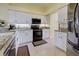 Modern kitchen with white cabinetry, granite countertops, and stainless steel appliances at 1125 Deardon Dr, Venice, FL 34292