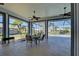 Spacious screened lanai with ceiling fans, outdoor dining area, and tranquil views at 1125 Deardon Dr, Venice, FL 34292