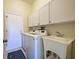Laundry room with washer, dryer, sink, and storage cabinets at 1125 Deardon Dr, Venice, FL 34292
