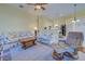 Bright living room featuring stylish sofas, a ceiling fan, and an open view into the kitchen at 1125 Deardon Dr, Venice, FL 34292