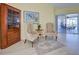 Sitting room with neutral walls, decorative rug, corner cabinet, and sliding glass doors at 1125 Deardon Dr, Venice, FL 34292
