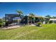 Screened-in pool with surrounding palm trees and well maintained grassy lawn at 1125 Deardon Dr, Venice, FL 34292