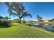 Picturesque waterfront view showcasing lush greenery, a tranquil pond, and neighboring homes at 1125 Deardon Dr, Venice, FL 34292