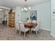 Dining room with wood-look tile floors, a wood table and upholstered chairs, and modern chandelier at 11575 Okaloosa Dr, Venice, FL 34293