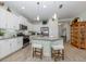 Modern kitchen boasts white cabinets, stainless steel appliances, and a spacious island with seating at 11575 Okaloosa Dr, Venice, FL 34293