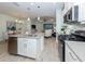 Bright kitchen featuring stainless steel appliances, an island sink, and an open view to the living room at 11575 Okaloosa Dr, Venice, FL 34293