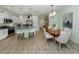 Bright kitchen with white cabinets, stainless appliances, an eat-in island and open to the dining area at 11575 Okaloosa Dr, Venice, FL 34293