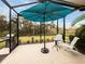 Enjoy outdoor dining in this screened lanai with a sun umbrella, grill and seating area at 11575 Okaloosa Dr, Venice, FL 34293