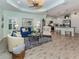 Open living space features wood floors, a ceiling fan, and white kitchen cabinetry at 11575 Okaloosa Dr, Venice, FL 34293