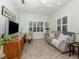 Comfortable living room with neutral walls, wood-look flooring, plantation shutters, and a sofa at 11575 Okaloosa Dr, Venice, FL 34293