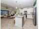 Open-concept living space with a kitchen island and stainless appliances with view of living room and lanai at 11575 Okaloosa Dr, Venice, FL 34293