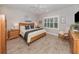 Comfortable main bedroom features wood-look tile flooring, plantation shutters, and wood furniture at 11575 Okaloosa Dr, Venice, FL 34293