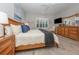 Comfortable main bedroom featuring wood-look tile flooring, plantation shutters, and a ceiling fan at 11575 Okaloosa Dr, Venice, FL 34293