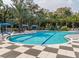 Community pool surrounded by palm trees and shaded lounge areas at 11575 Okaloosa Dr, Venice, FL 34293