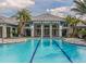 Large community pool surrounded by lounge chairs, beautiful clubhouse, and palm trees at 11575 Okaloosa Dr, Venice, FL 34293