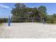Outdoor volleyball court with white sand and blue posts, perfect for recreational games at 11575 Okaloosa Dr, Venice, FL 34293