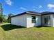 Exterior back of white stucco house features large yard and screened in porch at 12390 Talavera St, North Port, FL 34287