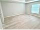 A bright, empty bedroom with light gray wood floors and a large window at 12390 Talavera St, North Port, FL 34287