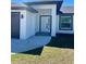 Welcoming front entrance with a modern design, featuring a covered porch and a well-maintained lawn at 12390 Talavera St, North Port, FL 34287