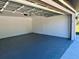 A two-car garage with epoxy floors, white walls, and a door at 12390 Talavera St, North Port, FL 34287