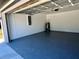 A clean garage featuring a blue floor and plenty of room for storage, with white walls at 12390 Talavera St, North Port, FL 34287