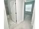 Hallway featuring a peek into the bathroom and bedroom with modern white doors and light gray floors at 12390 Talavera St, North Port, FL 34287