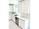 Kitchen sink area with stainless steel appliances, white cabinets, and marble countertops at 12390 Talavera St, North Port, FL 34287