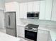 Close up of the kitchen with white cabinets, stainless steel appliances, and marble countertops at 12390 Talavera St, North Port, FL 34287