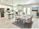 Bright kitchen features white cabinets, stainless steel appliances, island, and a dining area with view to the outdoor at 12390 Talavera St, North Port, FL 34287