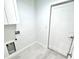 A bright laundry area with white cabinets, gray flooring, and modern fixtures at 12390 Talavera St, North Port, FL 34287