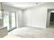Bright living room featuring wood-look flooring, neutral walls, and French doors leading to the outdoors at 12390 Talavera St, North Port, FL 34287