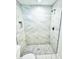Modern tiled shower featuring white marble-style walls and mosaic tile flooring at 12390 Talavera St, North Port, FL 34287