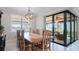 Inviting dining area with a large wooden table, pendant lighting, and views of the outdoors at 13016 Rinella St, Venice, FL 34293