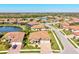 Stunning aerial view of a single-Gathering home with barrel tile roof, lush landscaping, and a community lake at 13750 Portenza Ln, Venice, FL 34293