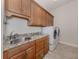 Well-equipped laundry room has wooden cabinets, granite countertops, and modern washer/dryer units at 154 E Tampa Ave, Venice, FL 34285