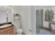 Bright bathroom featuring tile flooring, a glass shower, a toilet and a vanity with black countertop at 15688 Melport Cir, Port Charlotte, FL 33981