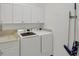 Laundry room features a washer, a dryer, upper cabinets, a sink and a countertop at 15688 Melport Cir, Port Charlotte, FL 33981