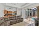 Living room with a large sectional couch and sliding doors leading to an outdoor pool area at 15688 Melport Cir, Port Charlotte, FL 33981