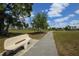 Enjoy the community park with beautiful walking path, benches, mature trees and lush green space at 15688 Melport Cir, Port Charlotte, FL 33981