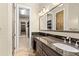 Bathroom vanity area with a large mirror, dark wood cabinets, and closet access at 158 E Tampa Ave, Venice, FL 34285