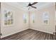 Bright bedroom with hardwood floors, a modern ceiling fan, and plantation shutters on the windows at 158 E Tampa Ave, Venice, FL 34285